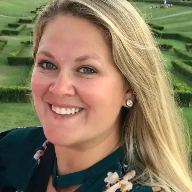 Kristen Pupa, smiling, in a garden in Europe